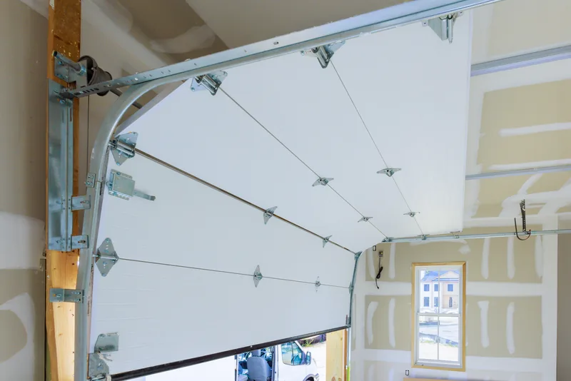 Sectional garage door panels, hinges and curved tracks viewed from inside
